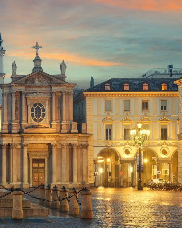 Piazza San Carlo la sera: la chiesa di San Carlo e i portici coi lampioni accesi