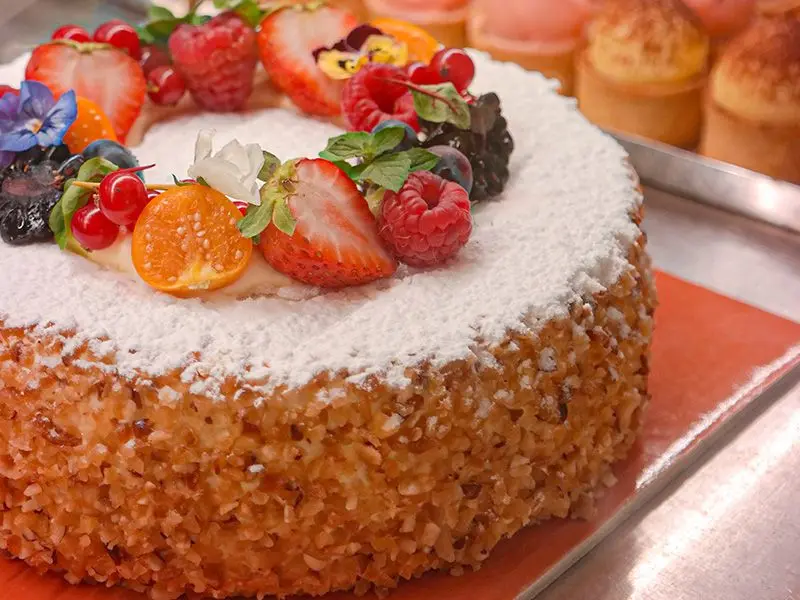 La torta Adri: zucchero a velo, granella di nocciole, frutti di bosco e fiori